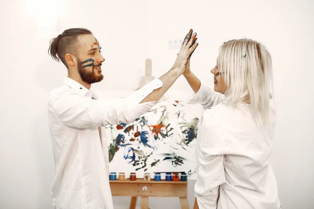 Couple painting on canvases in a studio, showing creative and artistic date night ideas for couples who love hands-on activities.