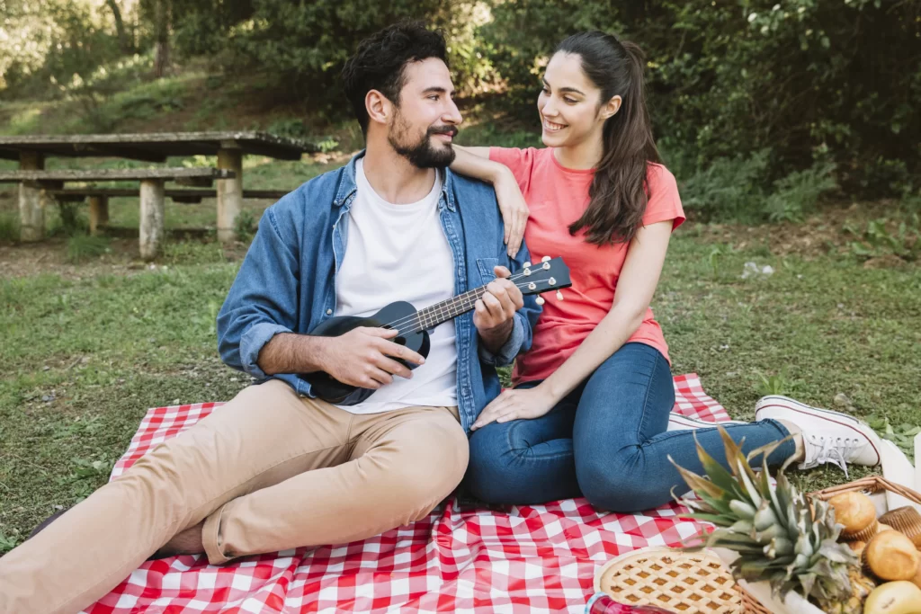 Young couple having a picnic in the park, showcasing fun date night ideas for active and outdoorsy pairs.