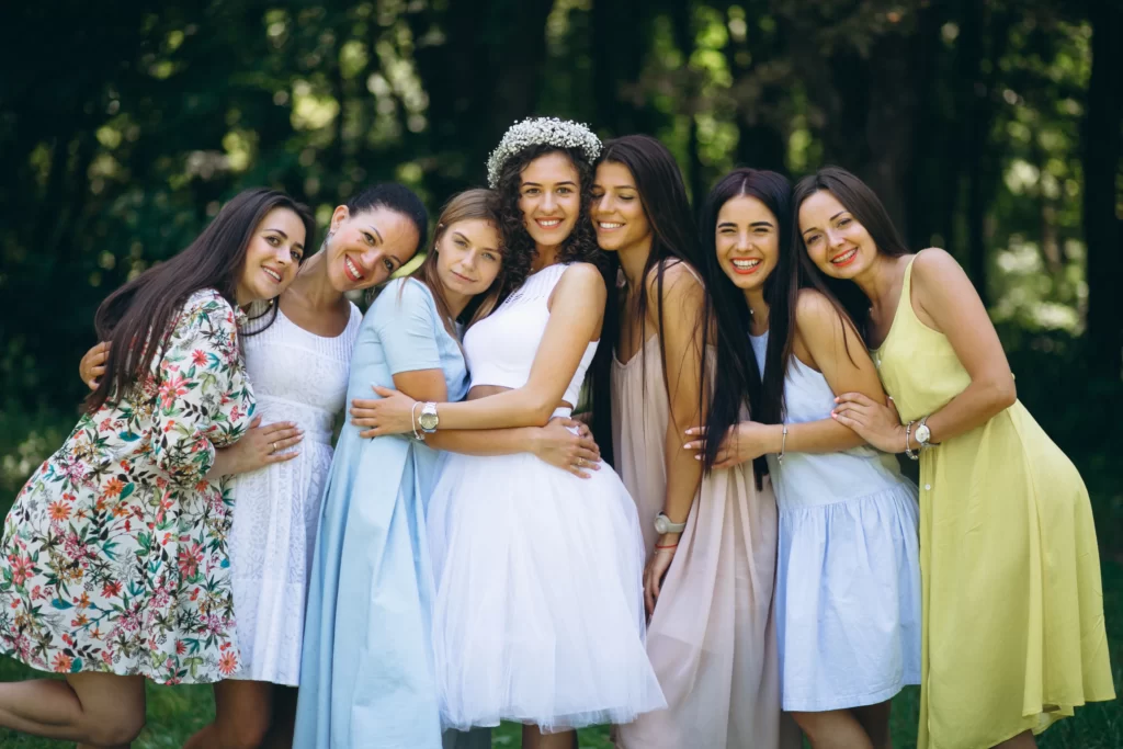 Bridesmaids and close friends wearing pastel and floral dresses at a wedding shower celebration.