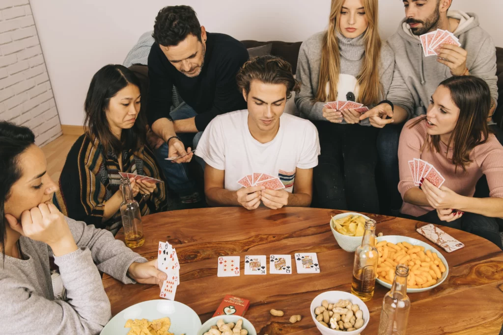 Group of friends enjoying a game night with board games and video game tournaments.