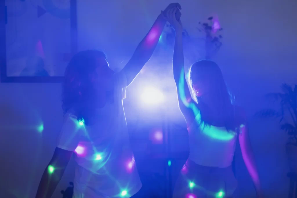 Glow-in-the-dark party setup with neon lights, glow sticks, and guests dancing.