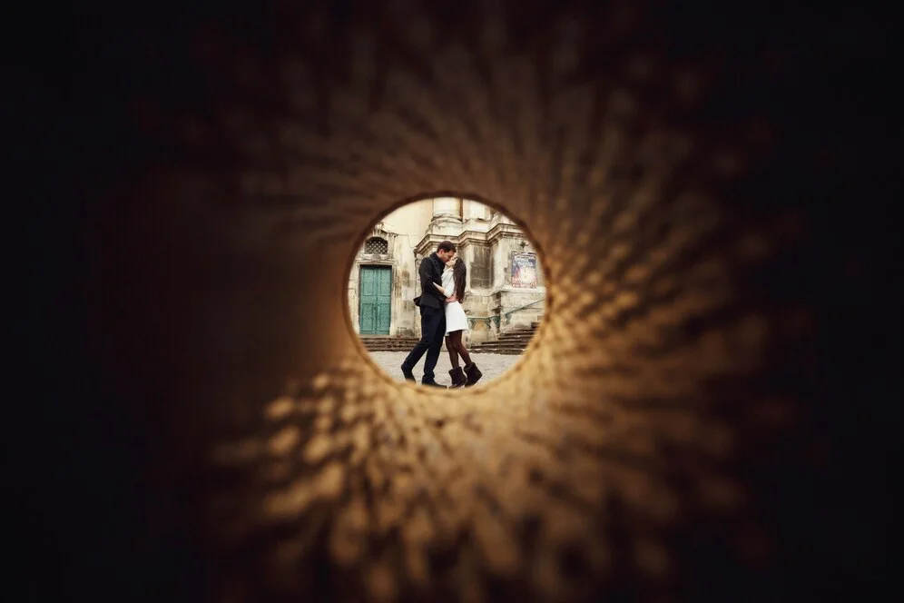 Photographer using a reflector to enhance lighting for a wedding photo.
