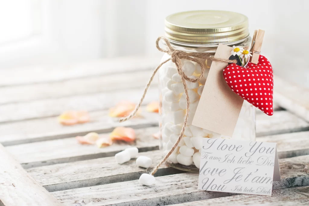 Guests writing memories in a memory jar at a wedding remembrance table.
