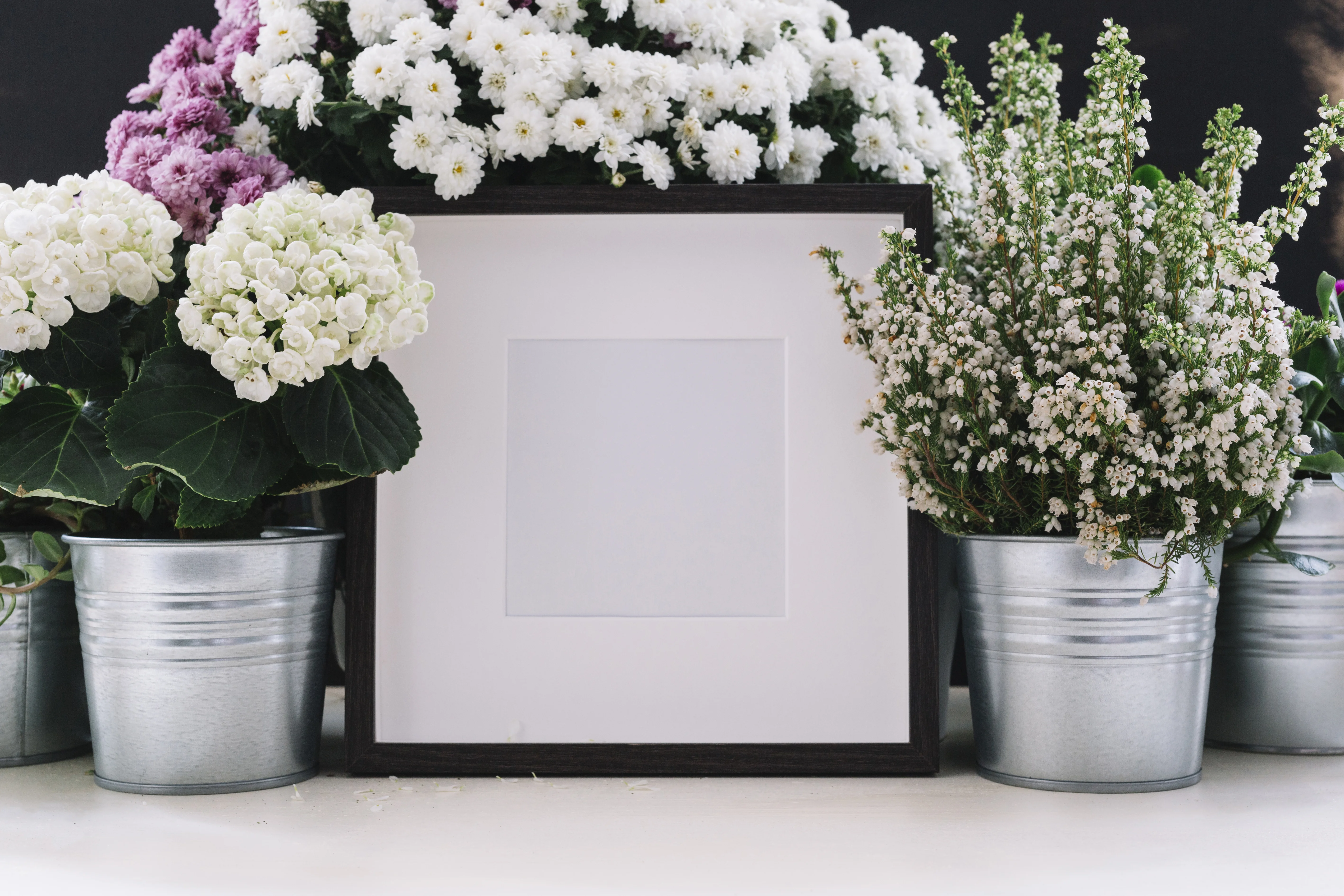 Memory table at a wedding with framed photos, candles, and floral decor