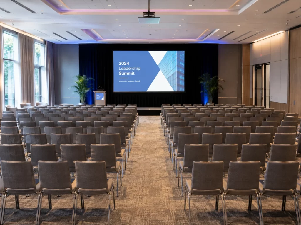 Theater-style conference room with 100 chairs arranged in rows facing a presentation stage